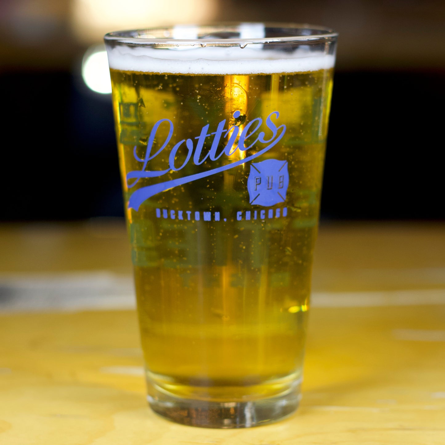 Add this unique local Chicago corner bar pint glass showcasing the iconic "Molly's By Day" and "Lottie's By Night" theme. Perfect for fans of the Chicago One TV series and Lotties Pub. Buy it at ShopLottiesPub.com!